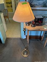 Full view of brass floor lamp with pleated shade