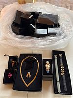Assorted Joan Rivers jewelry pieces and numerous branded boxes in plastic bin