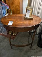 Full view of mahogany oval side table with fluted legs and stretcher