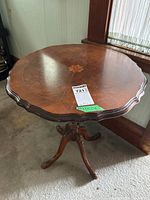 Full view of table showing scalloped top, central inlay, pedestal and legs