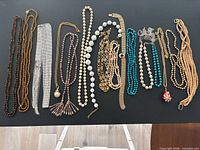 All necklaces laid out on black surface for overall view