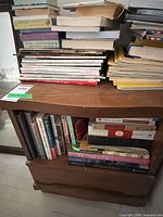 Front view of compact wooden bookshelf showing open shelf, drawer and surface condition