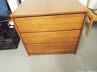 front view of wood dresser showing three drawers