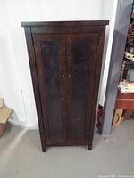 Front view of dark wood curio cabinet with glass doors