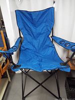 Front view of blue folding camping chair fully opened