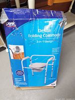 Front of Carex Deluxe Folding Commode retail box showing product name and image