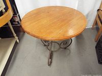 Full view of round wood top table with metal base