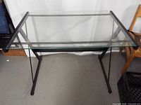 Full view of glass-top desk showing metal frame and overall structure