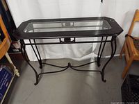 Full view of metal frame console table with glass top