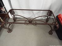 Full view of metal table base showing shape and scroll design