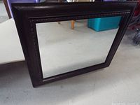 Full view of rectangular mirror lying on floor