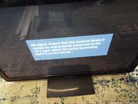Front view of powered-on Panasonic TV displaying no-signal message