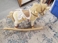 Full side view of plush rocking horse on wooden rocker base