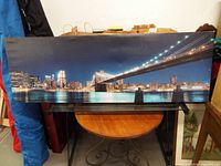 Full view of panoramic Brooklyn Bridge canvas print resting on table