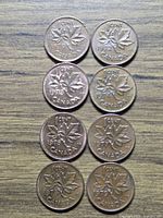 Eight coins laid out showing dates and maple leaf reverse