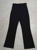 Front view of black maternity flare pants laid flat
