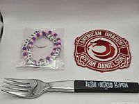 Overview of all four items: both bracelets, patch, fork
