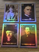 Four holographic trading cards laid out on wood surface: Butch Cassidy, William McKinley, William Frederick Cody, Grover Cleveland