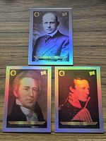 All three holographic trading cards displayed on wood surface