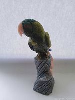 Front view of multigemstone parrot carving on stone base