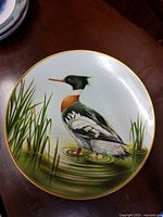 Front view of Red Breasted Merganser decorative plate showing bird illustration and gold rim