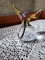 Dragon figurine wrapped around clear bubble glass orb, front view