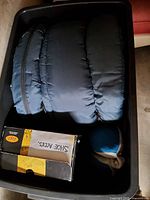 Sleeping bag, shoe kit box, travel pillow inside black tote