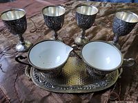 Full view of silver plated milk jug, sugar bowl on tray with four goblets