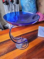 Full view of cobalt blue pedestal bowl on wood surface