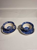 Two assembled cup and saucer sets front view