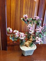 Front view of pink glass blossom bonsai in celadon pot