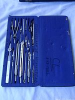 Open case showing complete set of drafting instruments in blue velvet