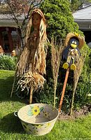 Full lot view showing scarecrow, tub planter, twig brooms and bird stake with sunflower hat