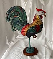 Front view of painted carved rooster on stand