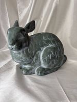 Front angled view of green rabbit statue