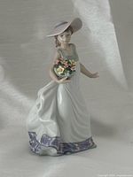 Front view of figurine showing dress, hat and basket