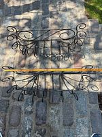 Both wrought iron planter holders laid out with tape showing overall width