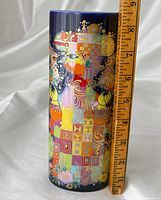 Full height view front of vase with ruler up to 10 inches showing height and wraparound colourful design