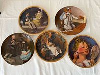 Front view of all five Norman Rockwell plates on table