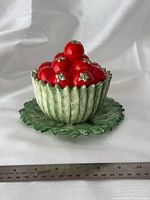 Front view of assembled condiment set showing basket, tomato lid, and underplate with scale ruler