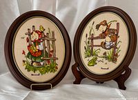 Both oval framed embroideries side by side