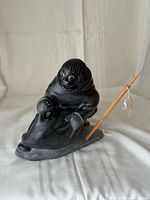 Full view of soapstone carving with spear inserted