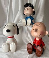 Front view of all three Peanuts character music boxes