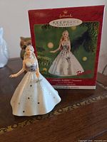 Front view of Barbie ornament beside original box