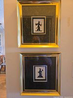 Both framed artworks stacked vertically on wall