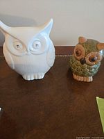 Both owl figurines side by side on tabletop