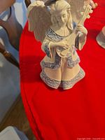 Front view of resin angel figurine holding lute