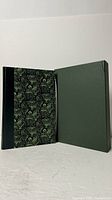 Quarter leather bound book with patterned cloth boards beside slipcase