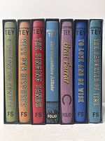 Spine view of all seven Folio Society Josephine Tey volumes in slipcases