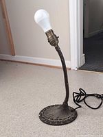 Full view of Aladdin cast metal table lamp with bulb for scale